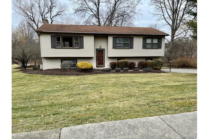 Bi-level home with a front lawn and a chimney