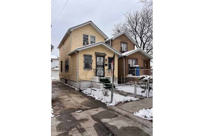 View of front of property featuring a fenced front yard and a gate