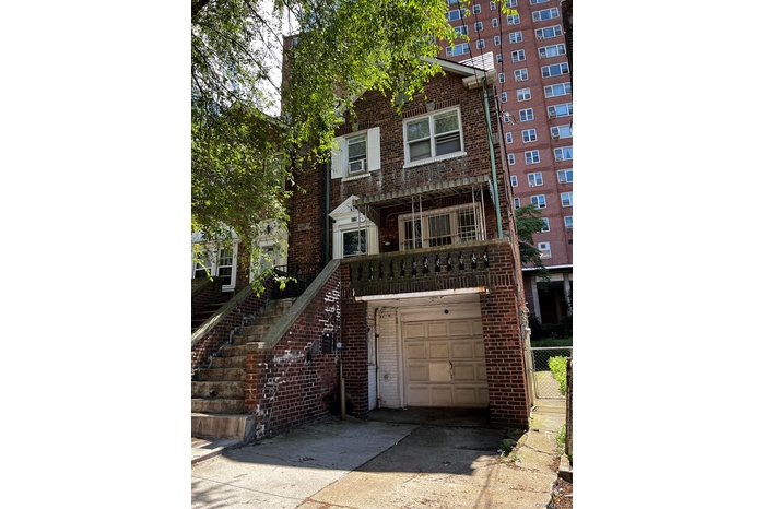 View of front of house with brick siding, stairs, concrete driveway, a balcony, and an attached garage