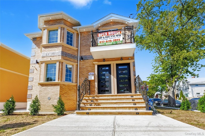 View of front of house with brick siding and a balcony