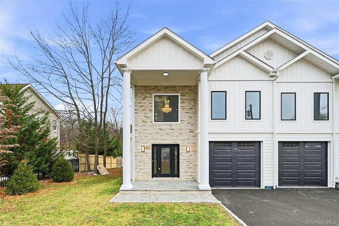 View of front of house with driveway, a garage, and board and batten siding