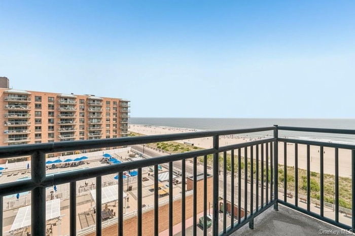 Balcony featuring view of water and beach