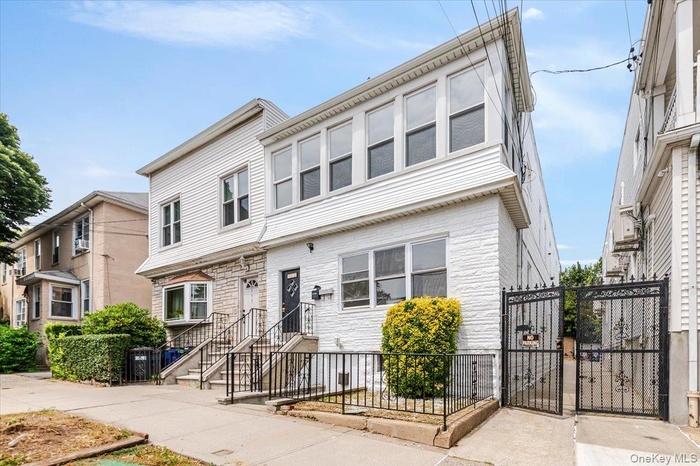 View of front facade featuring a gate and stone siding