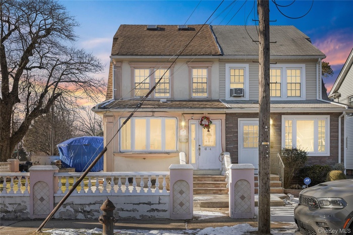 View of front of property with a shingled roof and a fenced front yard