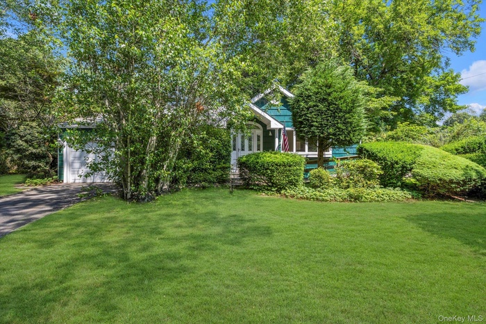View of front of home with a front yard, driveway, and a garage