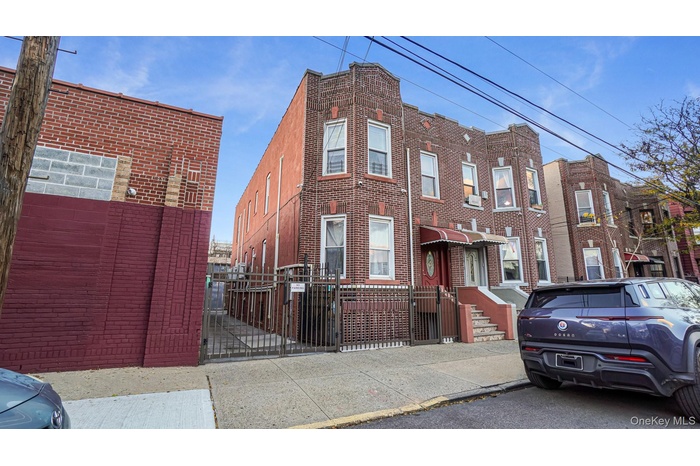 Traditional-style home with a gate, a fenced front yard, and brick siding