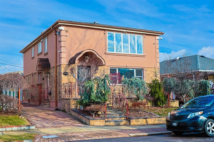 View of front facade featuring stucco siding and stone siding