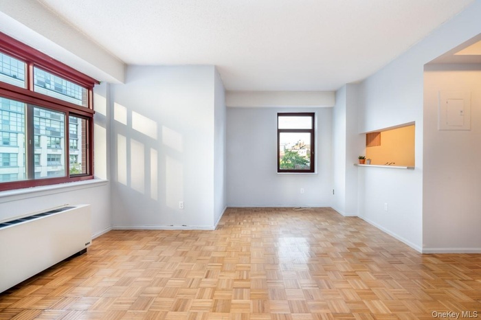 Unfurnished room featuring radiator and electric panel