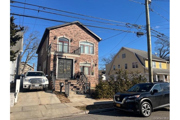 View of front of home with brick siding and a balcony