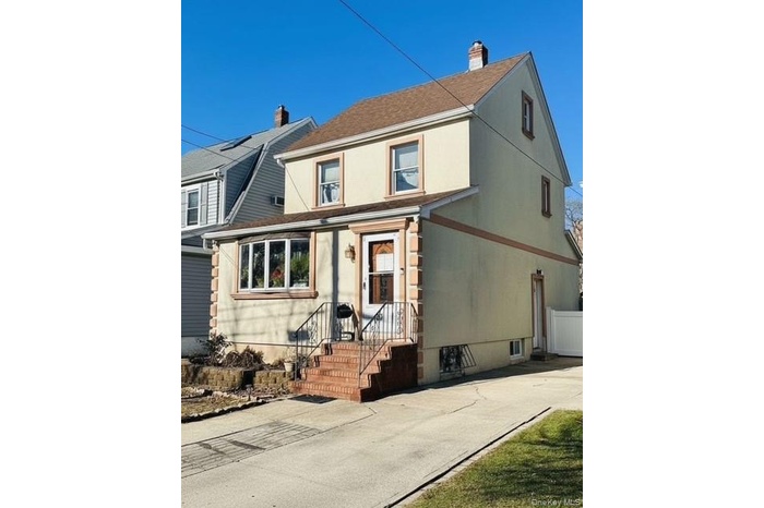 View of front of property with a chimney, roof with shingles, and stucco siding