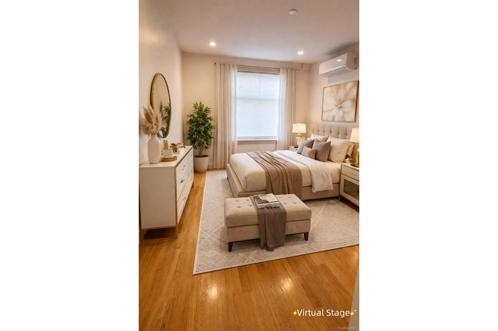 Bedroom featuring light wood-style flooring, a wall mounted AC, and recessed lighting