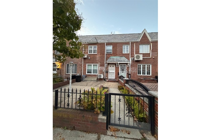 View of front facade featuring a high end roof, a fenced front yard, a gate, and brick siding