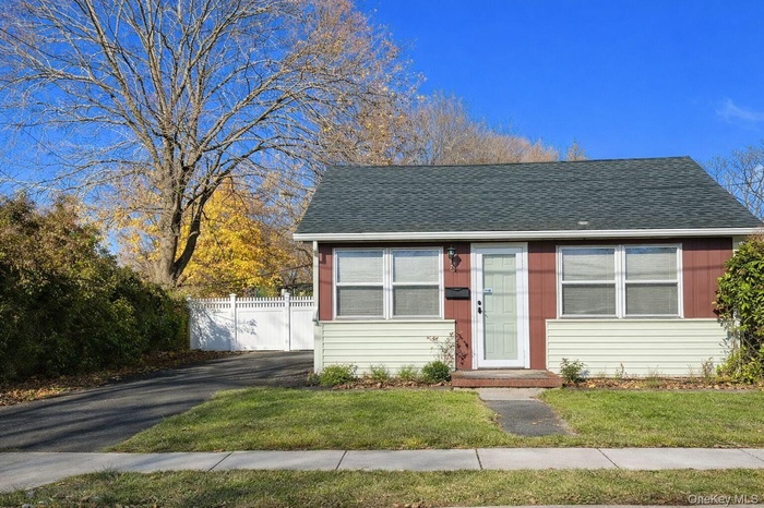 Bungalow featuring a shingled roof and driveway