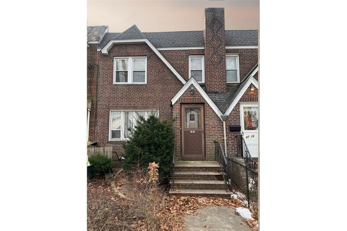View of front of home featuring brick siding, a shingled roof, and a chimney