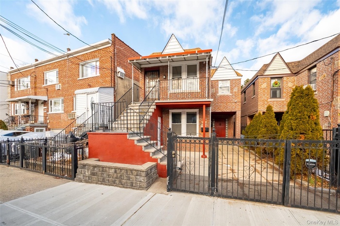 View of front of house with a gate, a fenced front yard, and brick siding