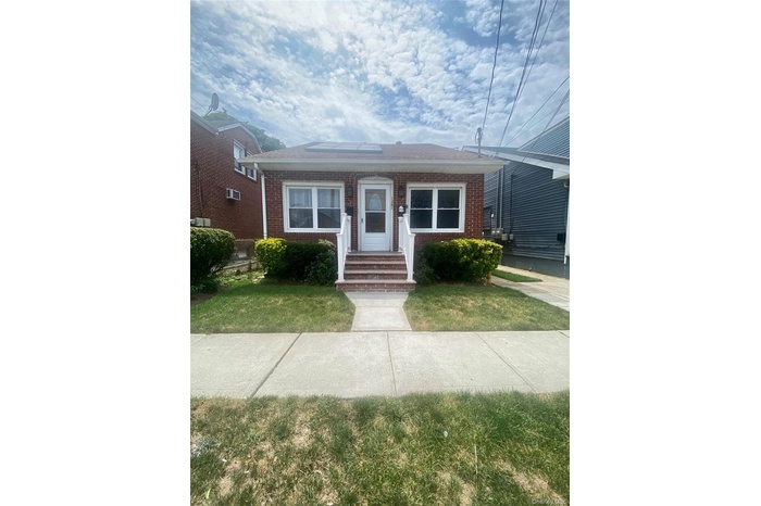View of front of house featuring brick siding and a front yard