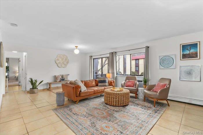 Living room with a baseboard heating unit and light tile patterned flooring
