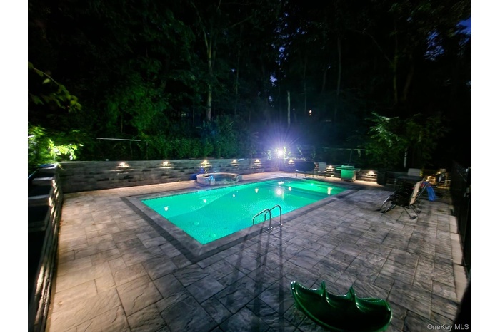 View of swimming pool featuring a patio area and a pool with connected hot tub