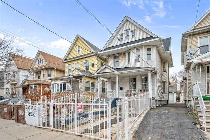 View of front of property featuring a fenced front yard, a porch, a residential view, and a gate