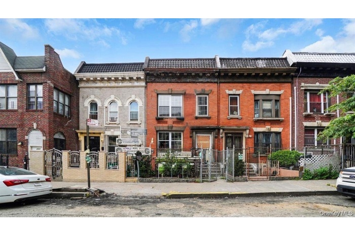 View of front of house with brick siding and a fenced front yard