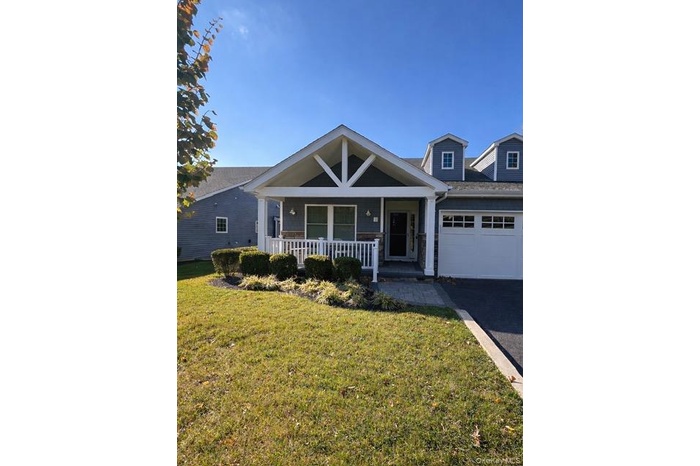 Inviting front porch with driveway & garage