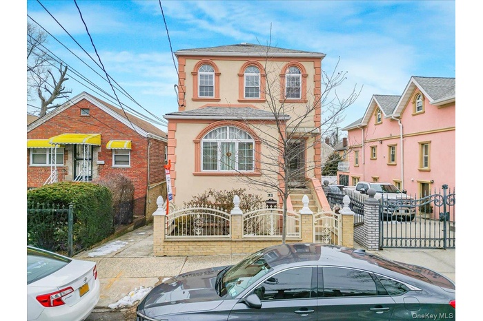 View of front of house with a fenced front yard, a gate, and stucco siding