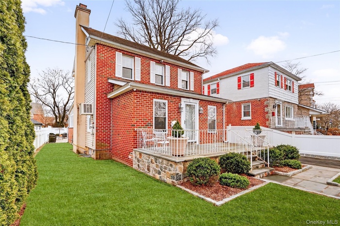 View of front of property featuring a chimney and brick siding
