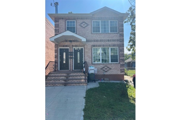 View of front of house with brick siding and a front yard