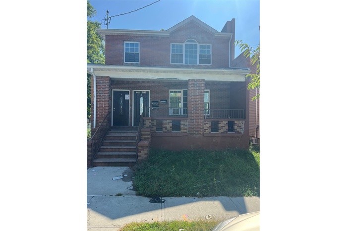 View of front of property with covered porch and brick siding