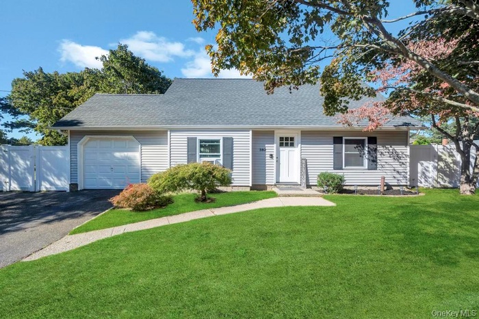View of front facade with roof with shingles, driveway, and an attached garage