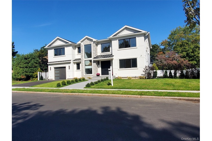 View of front of property with a garage & landscaping