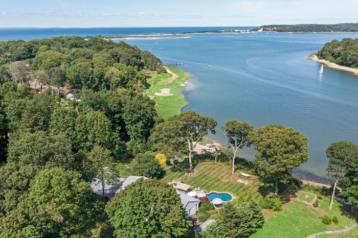 Aerial view of property and surrounding area with a nearby body of water