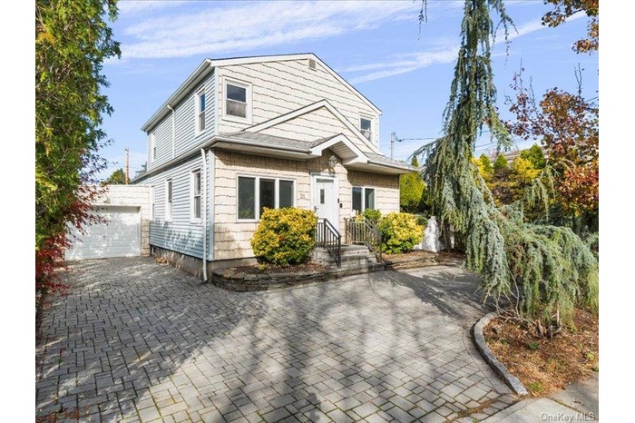 View of front facade with a patio and driveway