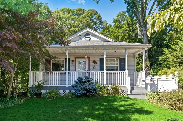 View of front of home featuring a porch, a front yard, and a shingled roof