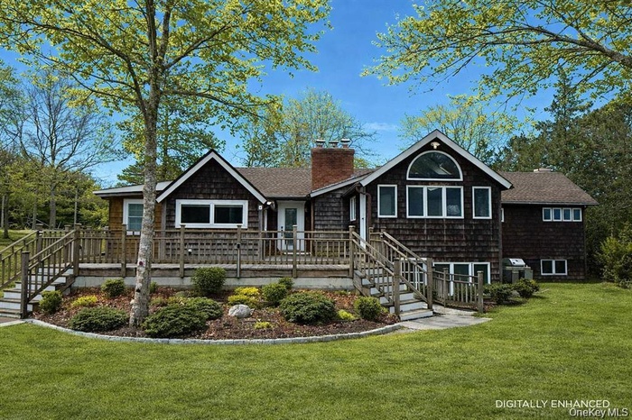 View of front of property featuring stairway, a front yard, and a wooden deck