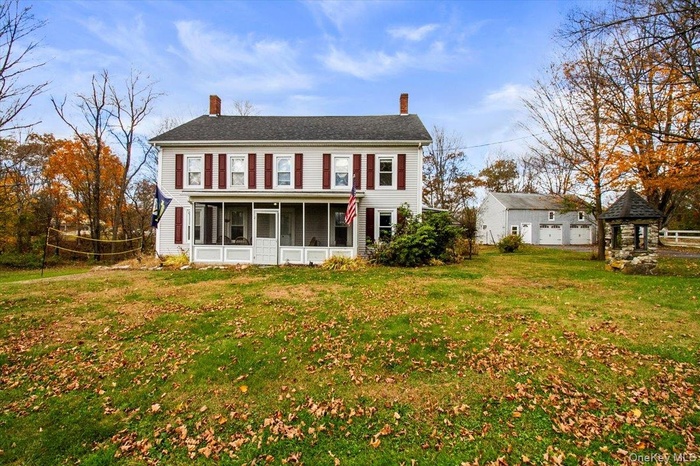 Colonial home featuring a front yard and porch