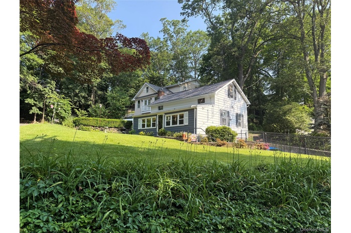View of front of property with view of wooded area