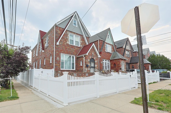 English style home with a fenced front yard and brick siding