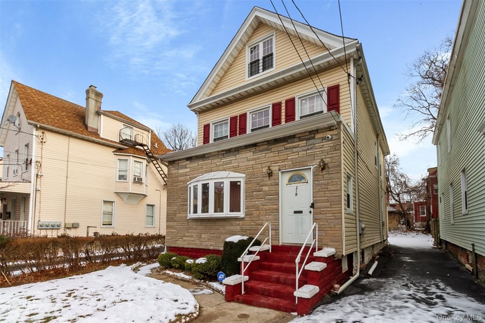 The front entrance opens into a welcoming living, with staircase leading to the second floor unit.