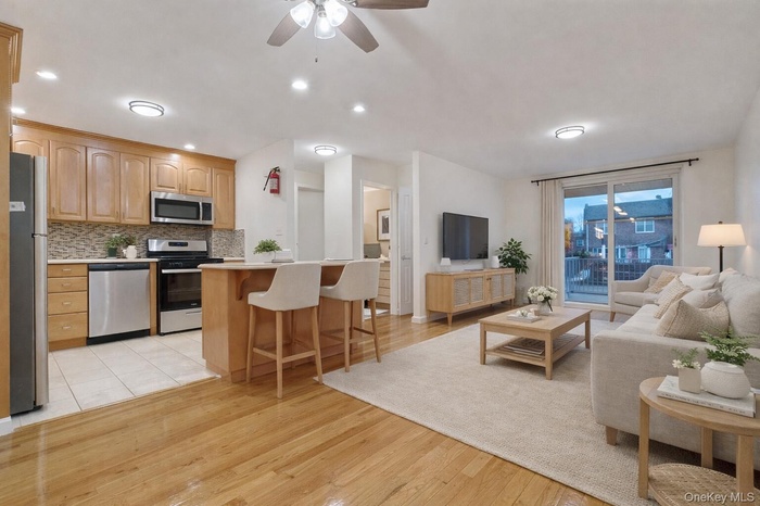 Living area featuring light wood-type flooring, ceiling fan, and recessed lighting