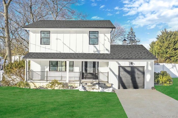 View of front facade featuring a porch, driveway, roof with shingles, a garage, and board and batten siding