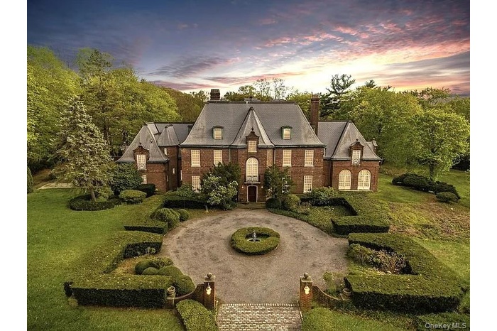 French country home with a chimney, a yard, and brick siding