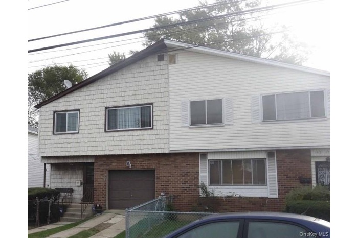 View of front of home with brick siding and a garage