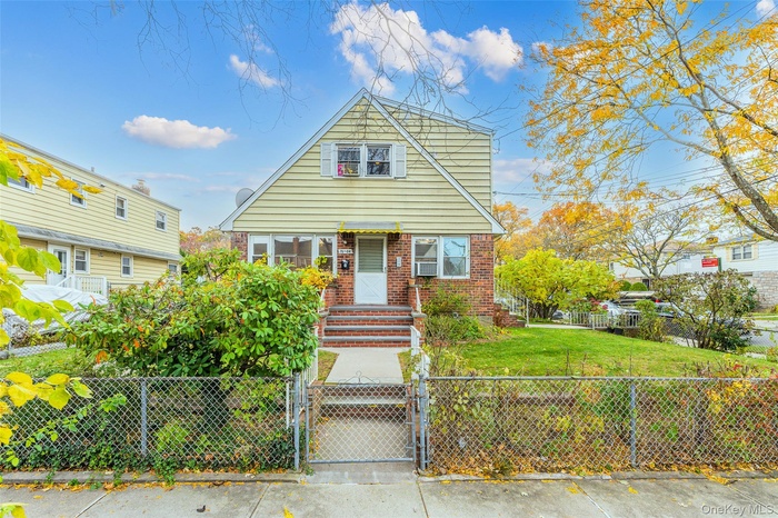 Bungalow-style home with a gate, a fenced front yard, and brick siding