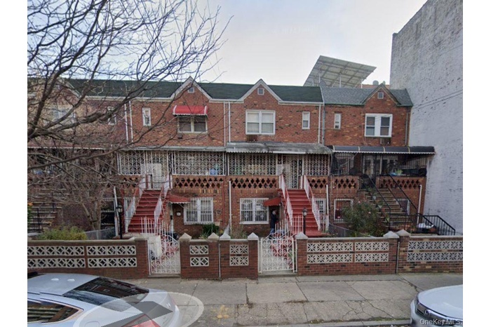 View of front of home featuring a fenced front yard, a gate, and brick siding