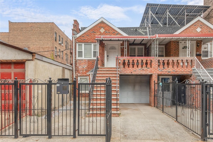 View of front of property featuring a fenced front yard, a gate, brick siding, and stairway