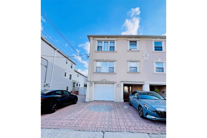 View of front of home with stucco siding and decorative driveway