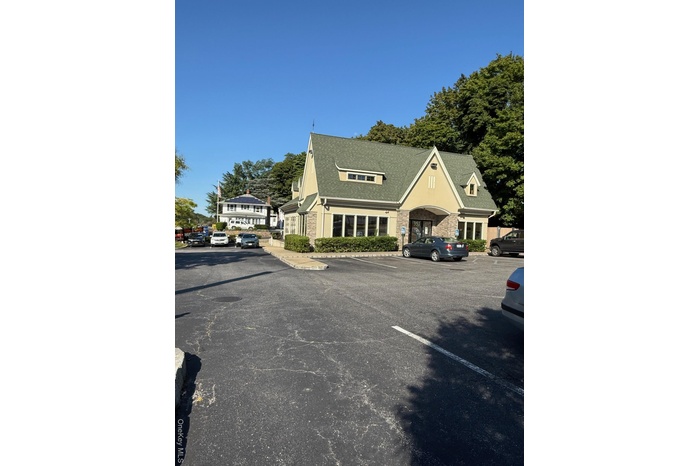 View of building exterior featuring uncovered parking