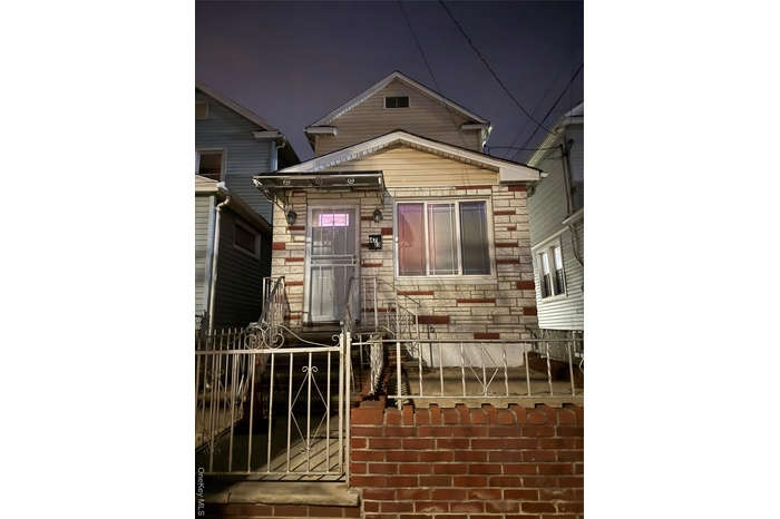 Exterior entry at twilight featuring stone siding and a gate
