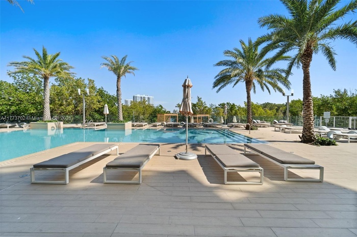 Striking twin-tower waterfront development surrounded by lush mangroves and shimmering bay waters, offering a sophisticated urban retreat with resort-